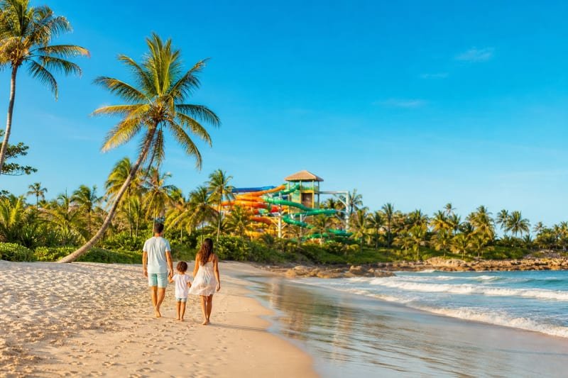 Família caminhando na Praia de Porto das Dunas perto de parque aquático